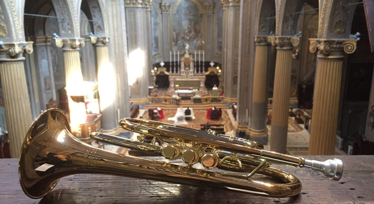 Immagine decorativa per l'articolo Anima Musica... Matrimoni. Foto di una cornetta in chiesa, sullo sfondo due sposi durante la cerimonia