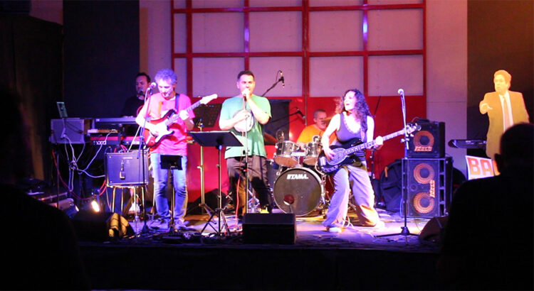 I musicisti della band Back to the Canistracci Oil Live '80 sul palco con i loro strumenti durante un concerto