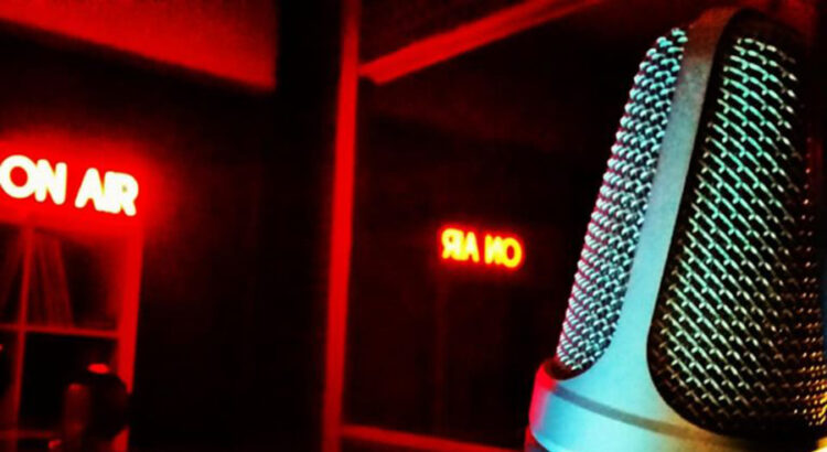 Immagine decorativa per l'articolo. Foto di un microfono, sullo sfondo la scritta "On Air"