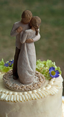 Immagine decorativa per l'articolo Anima Musica... Matrimoni. Foto di due statuine di sposi su una torta nuziale